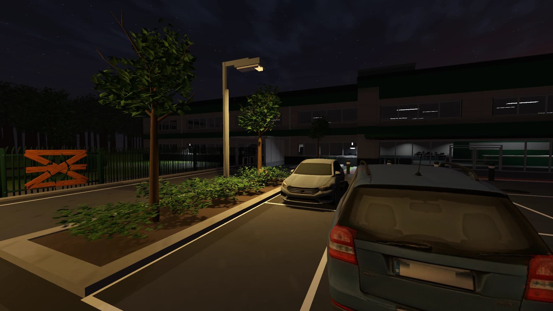 Warm yard lighting and tree shadows beside parked cars and the office entrance at night
